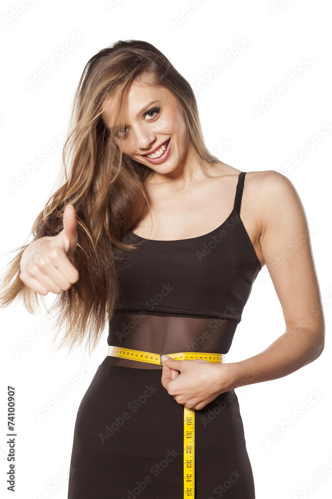 happy young woman measure her waist and showing thumbs up happy young woman measure her waist and showing thumbs up