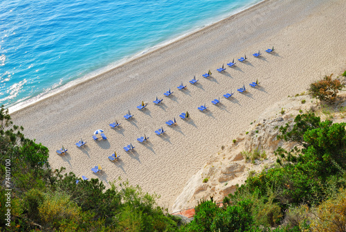Sandy beach with empty sunbeds viewed from above photo