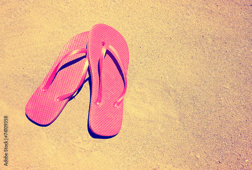  summer vacation background with a pair of sandals on a sandy beach