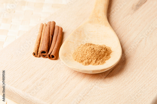 Fototapeta Naklejka Na Ścianę i Meble -  cinnamon sticks and cinnamon powder on a wooden spoon