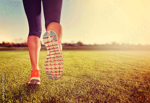  an athletic pair of legs on grass during sunrise or sunset - healthy lifestyle 