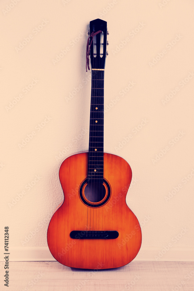 Fototapeta premium Guitar on the floor on beige background