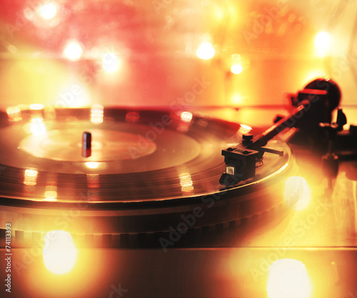 a close up of a record player with bokeh lights