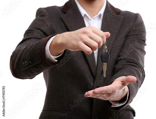 Businessman holding car key isolated on white