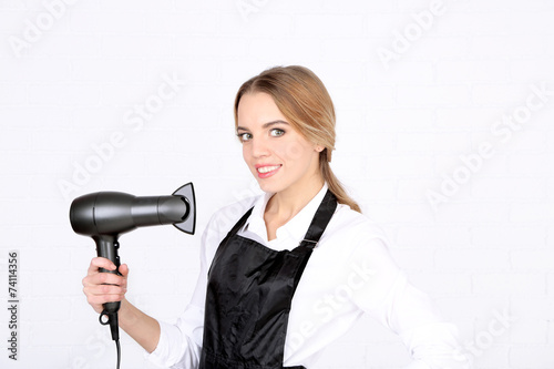 Beautiful girl hairdresser on light background