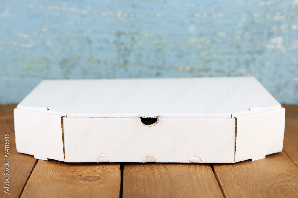 Empty cardboard pizza box on wooden table Empty cardboard pizza box on wooden table