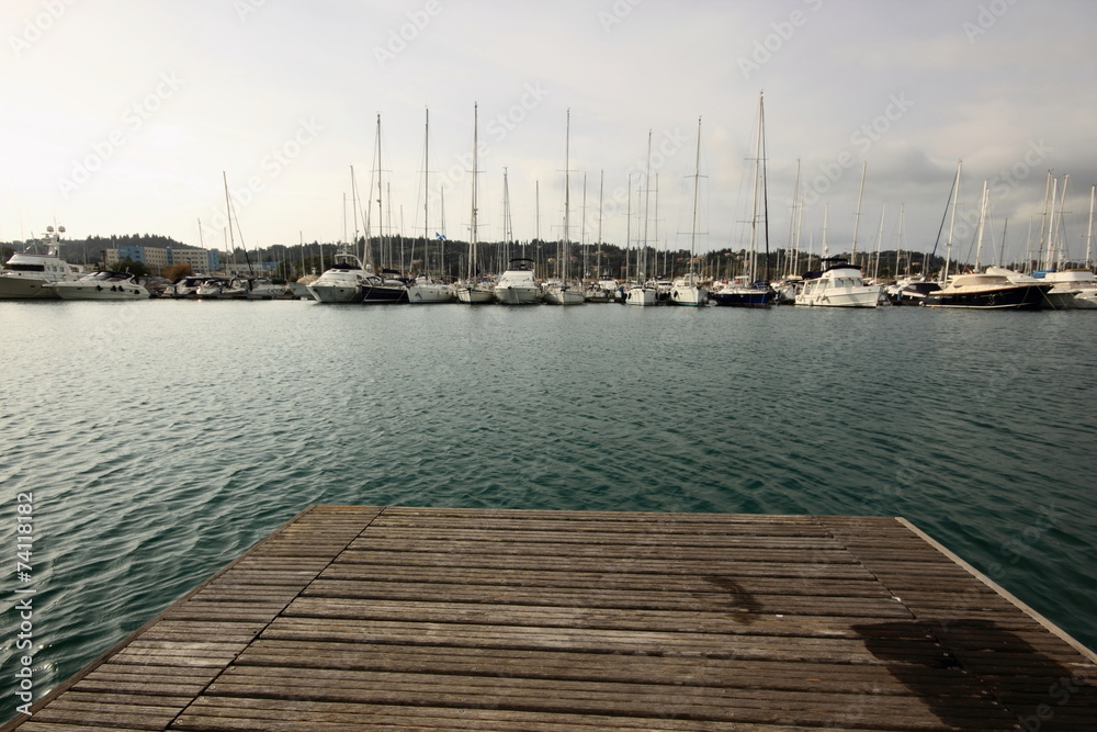 wood marina pontoon with sail boats and yachts