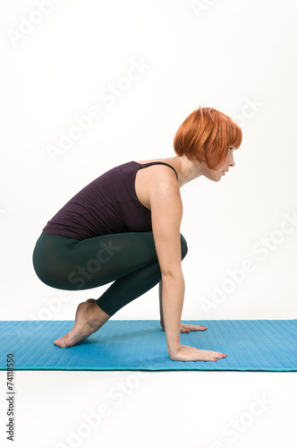 Yoga posing on a gray studio background
