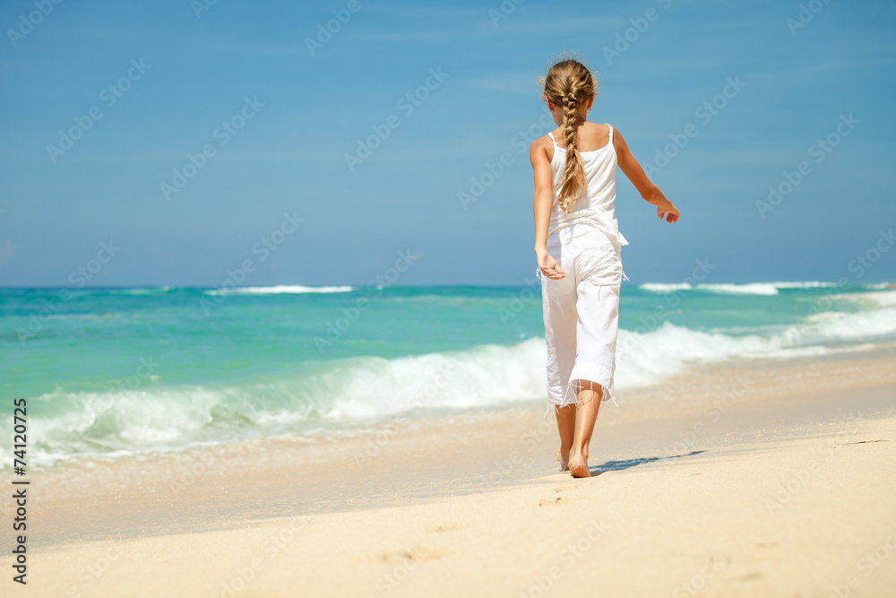 Teen girl walking on the beach at the day time