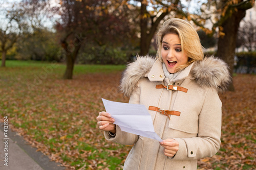 surprised woman reading a letter photo