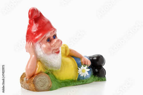 Gartenzwerg liegend mit Blume in der Hand photo