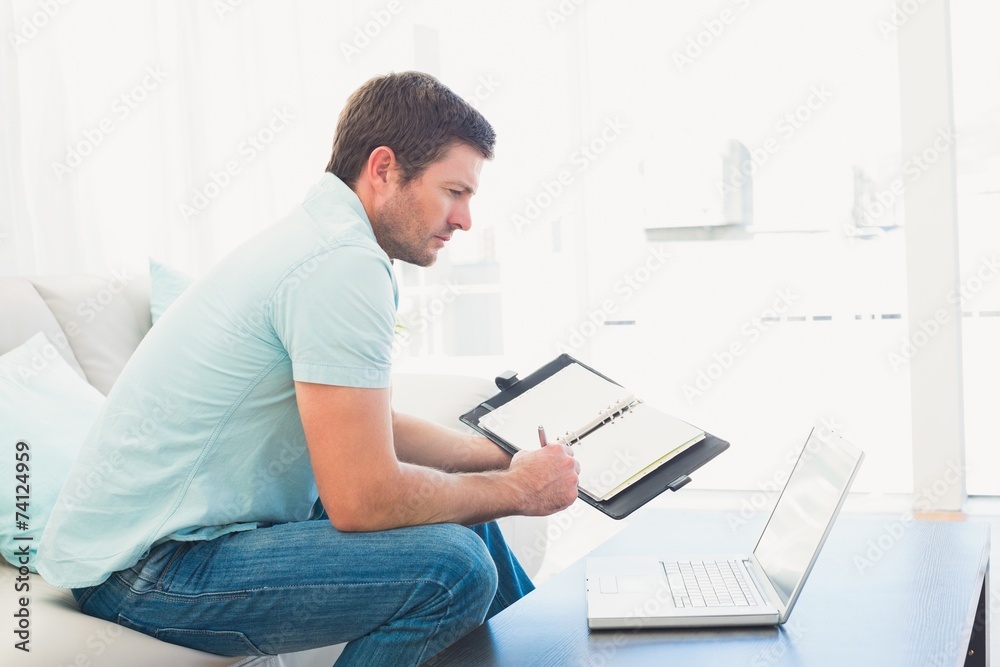 focused man on a laptop with a notebook focused man on a laptop with a notebook