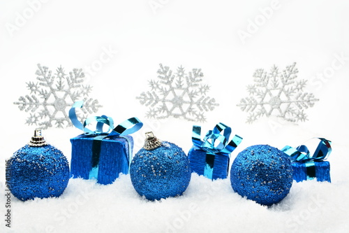 Blue christmas gifts and baubles with snowflakes on snow photo