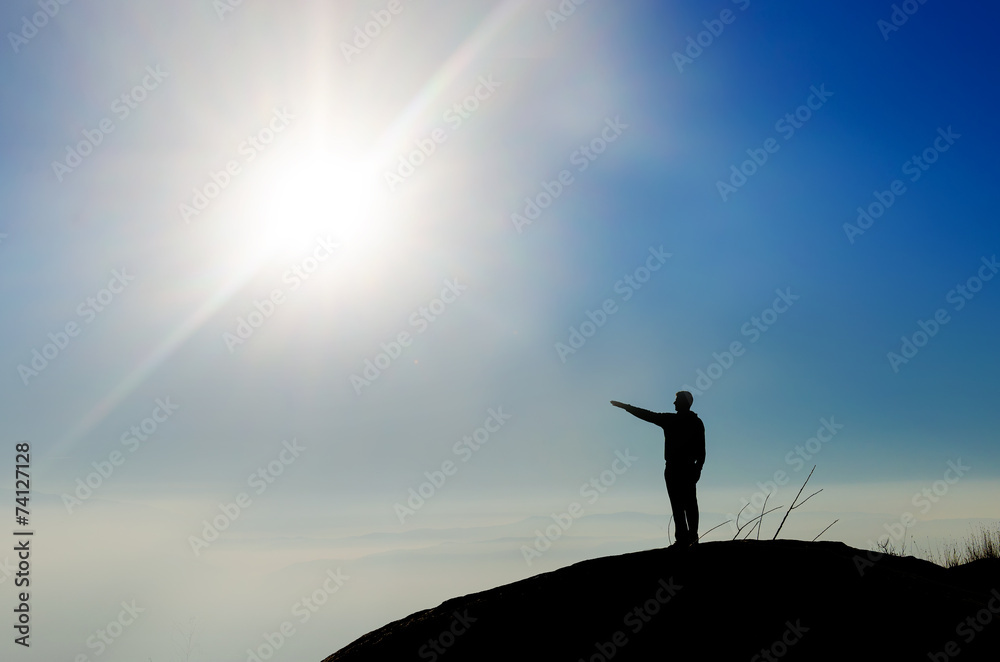 Silhouette of a champion on mountain top pointing