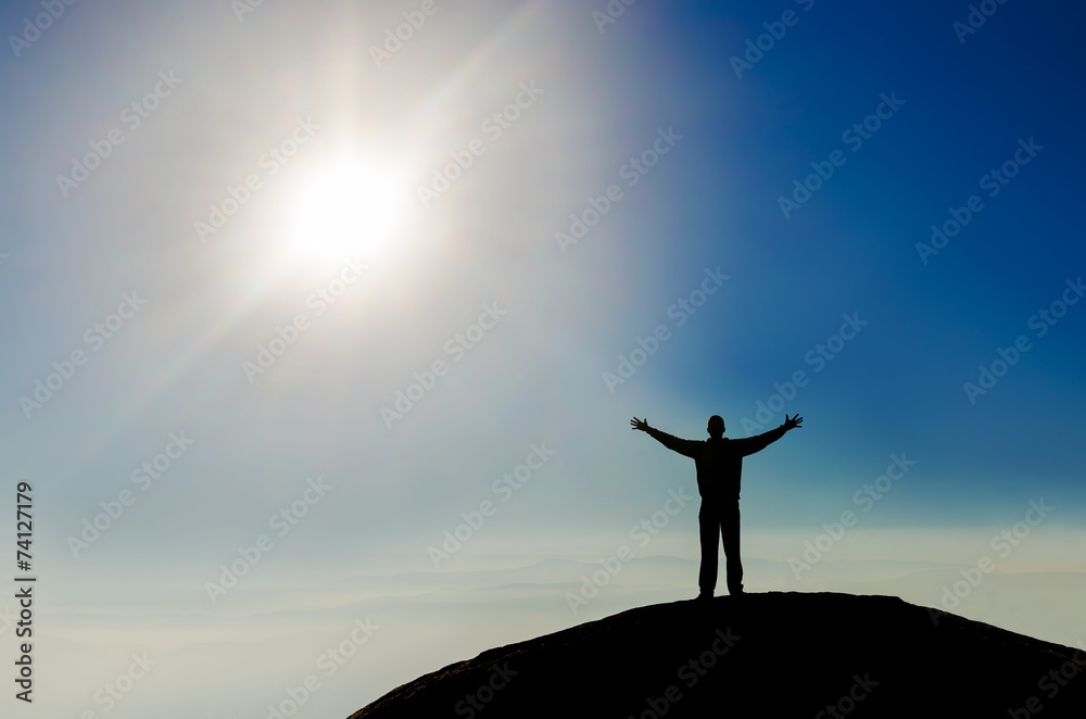Silhouette of successful man on the top of the world