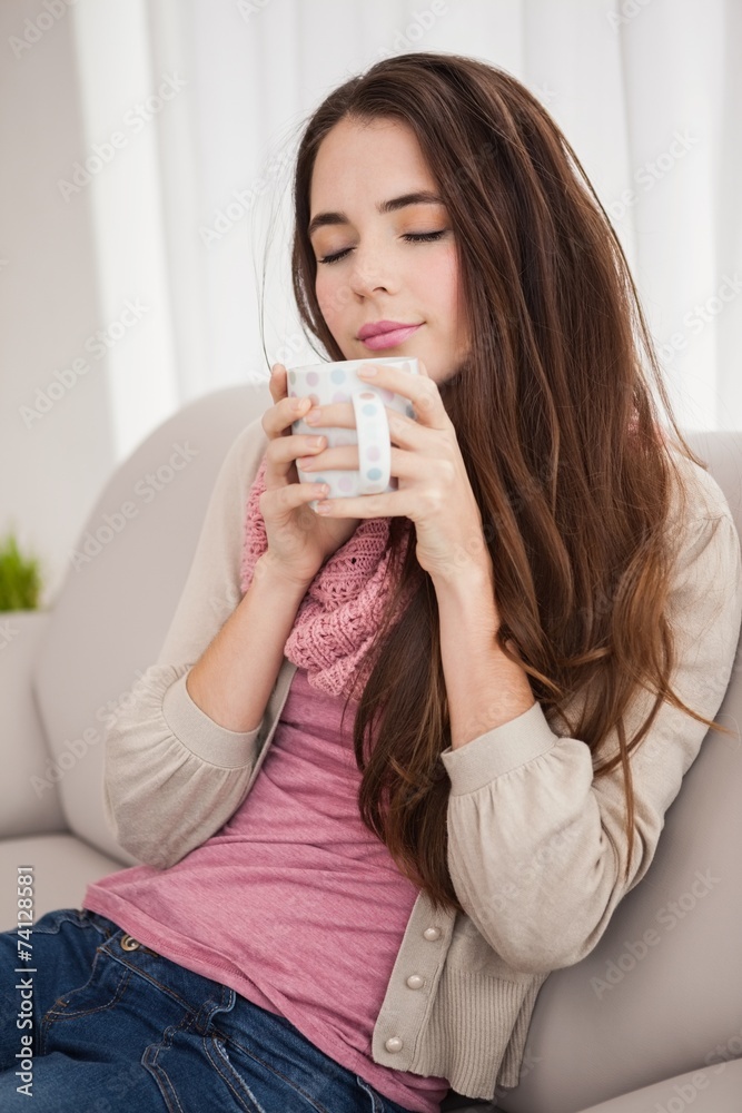 Pretty brunette having coffee on the couch Pretty brunette having coffee on the couch