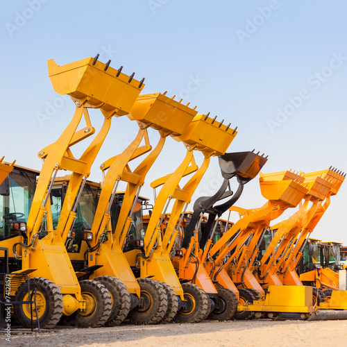 The row of heavy construction excavator machine  against blue sk photo