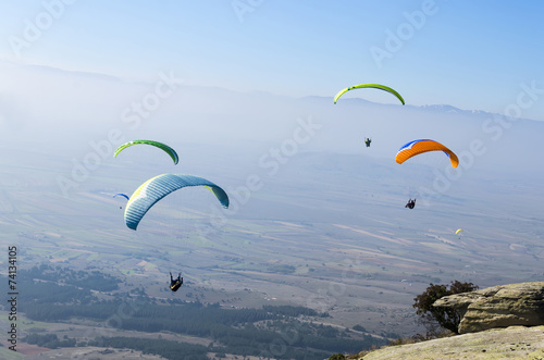 Colorful paragliders above the mountain range 