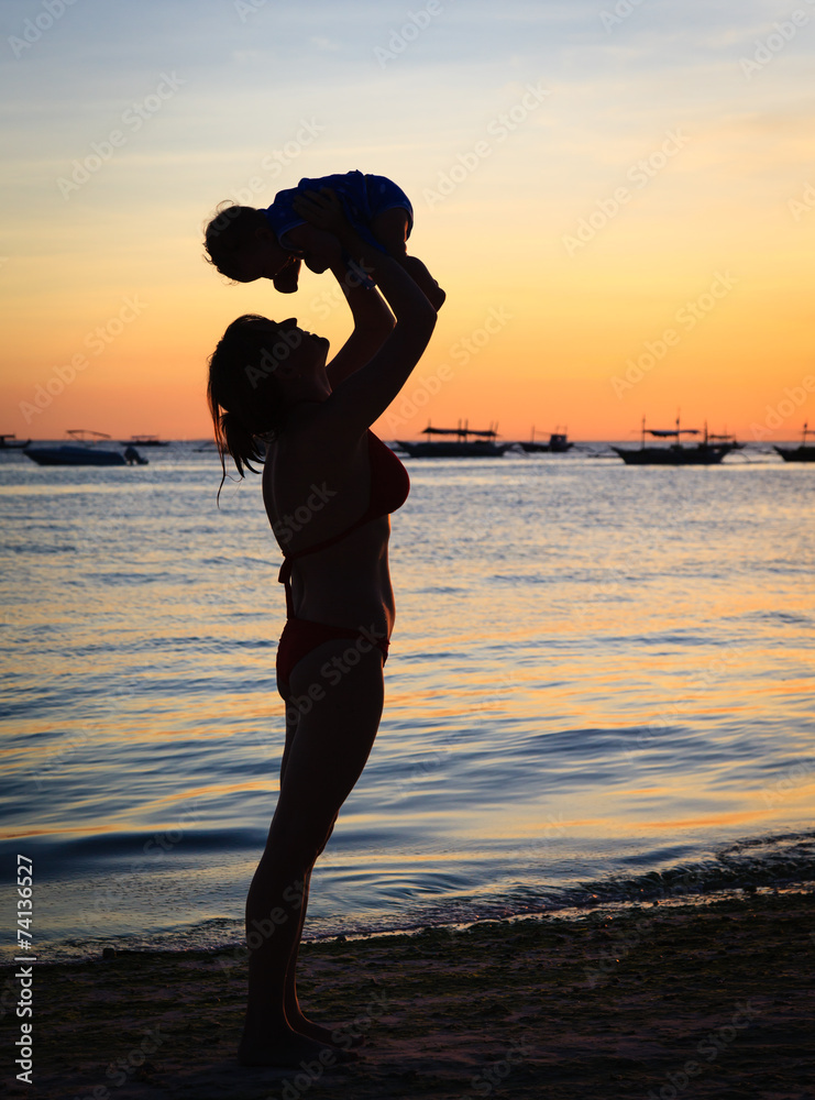 Fototapeta premium mother and daughter having fun at sunset beach