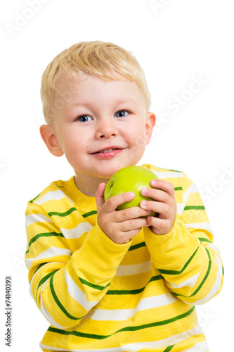 little boy eating green apple