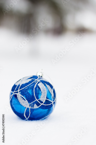 Blue xmas ornaments on snowy background