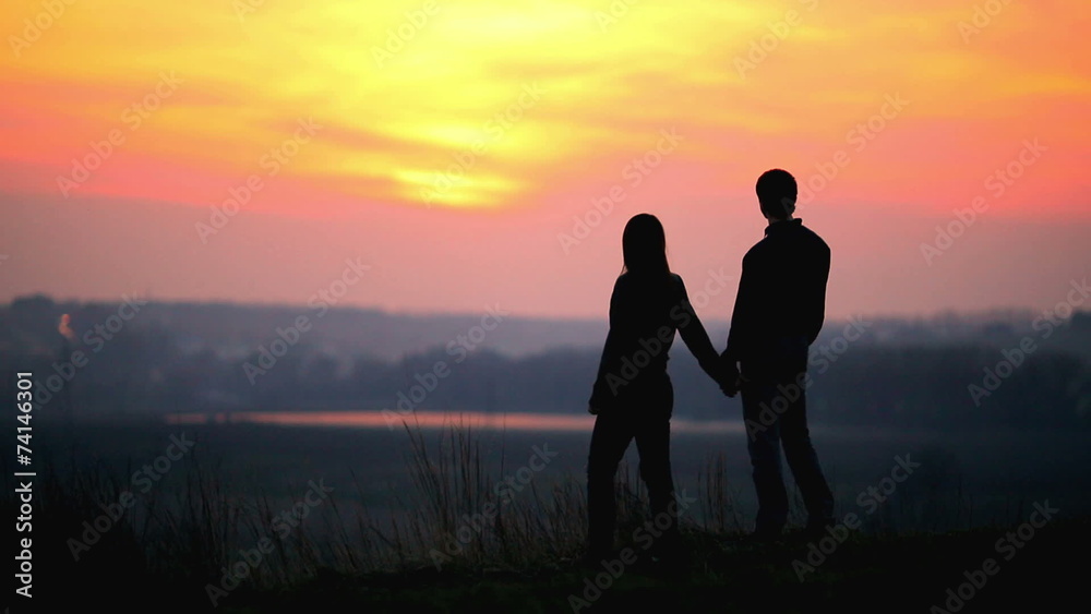 The pair, lovers, walk by sunset background on the top The pair, lovers, walk by sunset background on the top