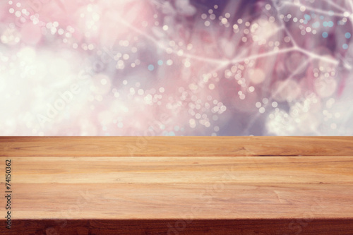 Empty wooden deck table over winter bokeh background