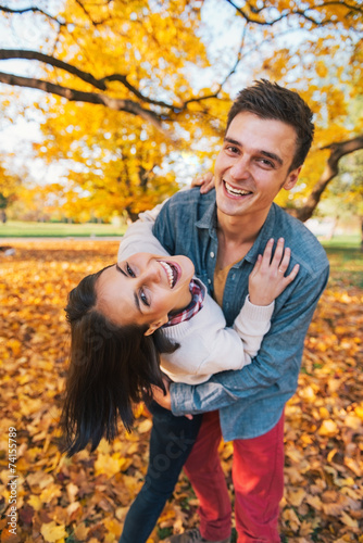 Portrait of happy young couple outdoors in park in autumn  © Alliance