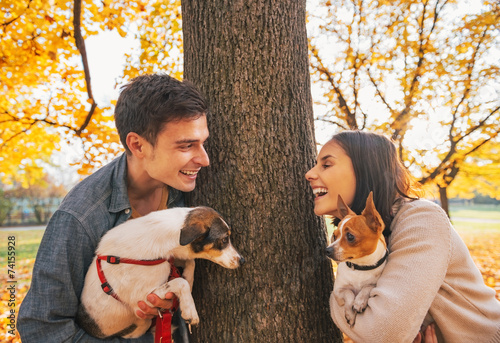 Photography Portrait of happy young couple with dogs outdoors in autumn park