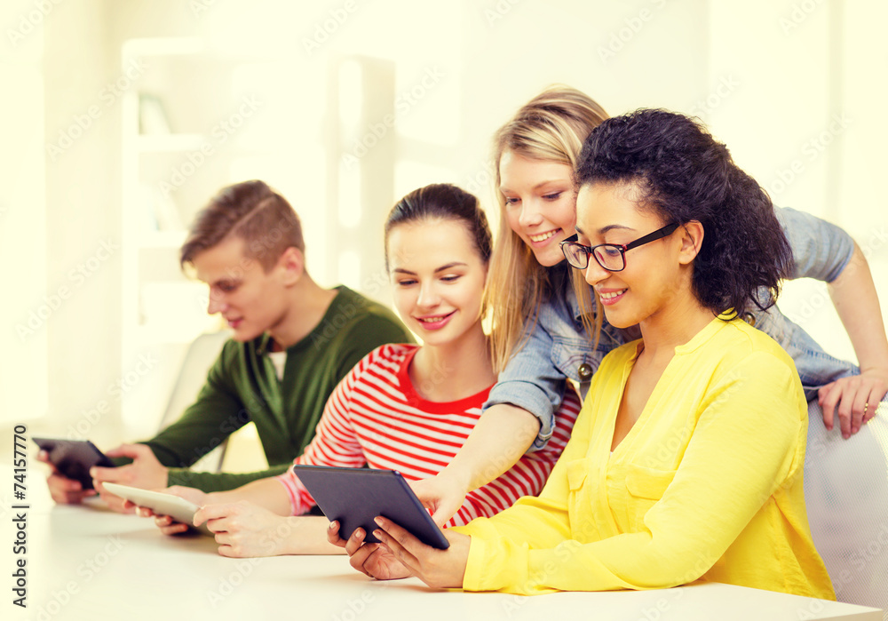 smiling students looking at tablet pc at school smiling students looking at tablet pc at school