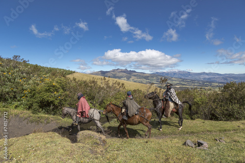 Andean landscape with ecuadorian horsemen riding through mountain highlands. Ecuador, cowboy, andes, horse, gaucho, adventure, travel, tourism, ecotourism, work, mammal, tradition, poncho, indigenous