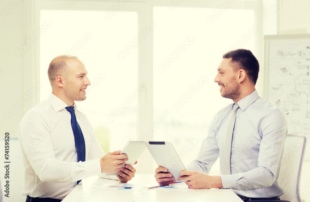 two smiling businessmen with tablet pc in office two smiling businessmen with tablet pc in office