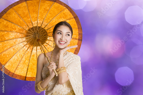Thai woman dressing traditional costume holding an umbrella