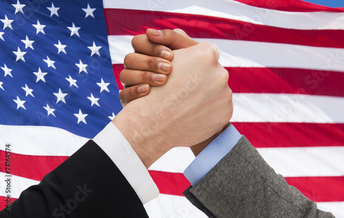close up of hands arm wrestling over american flag