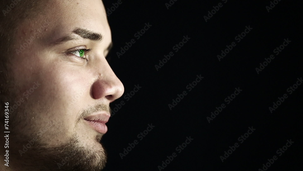 Close up profile face of a young man with green eyes. Close up profile face of a young man with green eyes.