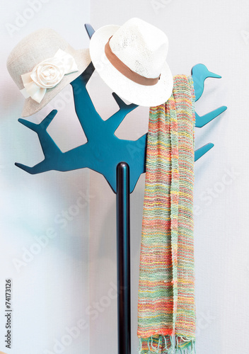 Bright colored scarf with hat hanging on a rack. in a dressing r