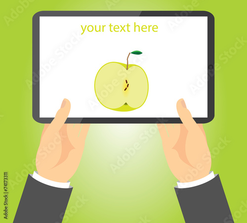 Half green apple on a tablet held in hands