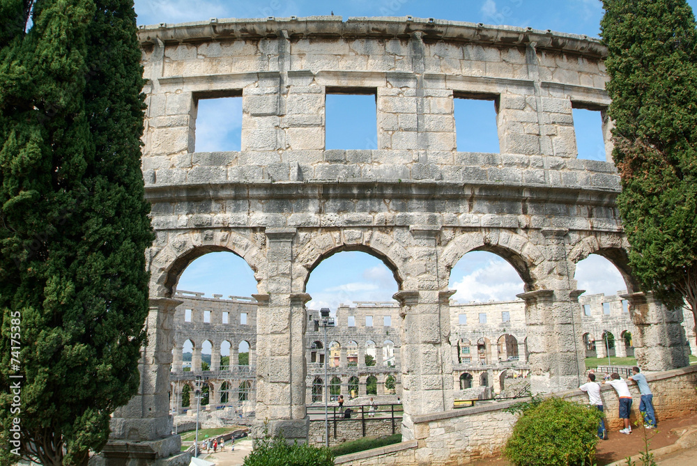 Tourists walking on the ruins of Roman amphitheatre at Pula