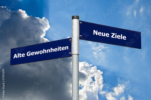 Straßenschild vor bewölktem/blauen Himmel mit Schriftzug 'Alte Gewohnheiten' vs. 'Neue Ziele' photo