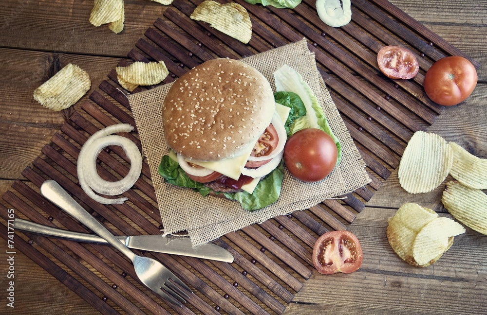 hamburger with cheese, tomato, onion and lettuce
