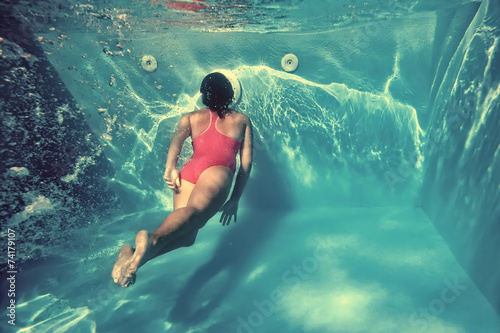 Girl swimming underwater in pool. © Orlando Florin Rosu
