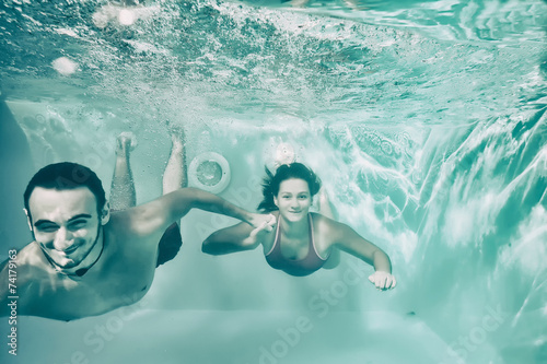 Girl and boy swimming under...