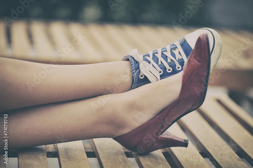 Woman legs in different shoes photo
