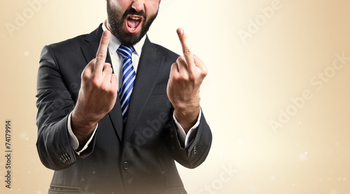 Young businessman doing the horn sign over white background