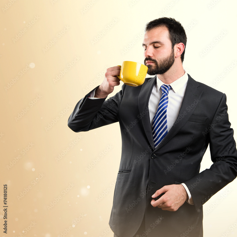 Young businessman drinking a coffee over white background Young businessman drinking a coffee over white background