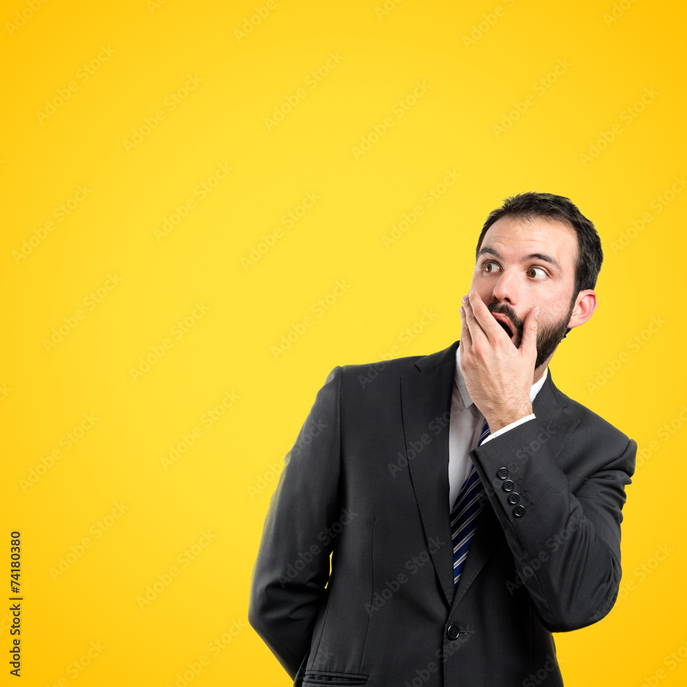 Businessman surprised over yellow background