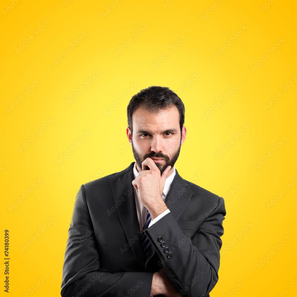 business man thinking over yellow background business man thinking over yellow background