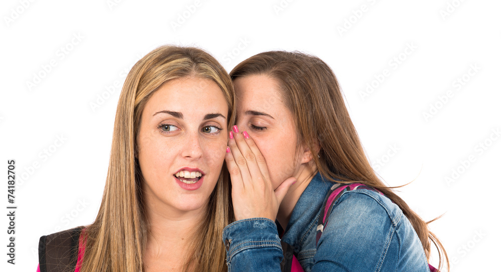 Student women whispering over white background Student women whispering over white background
