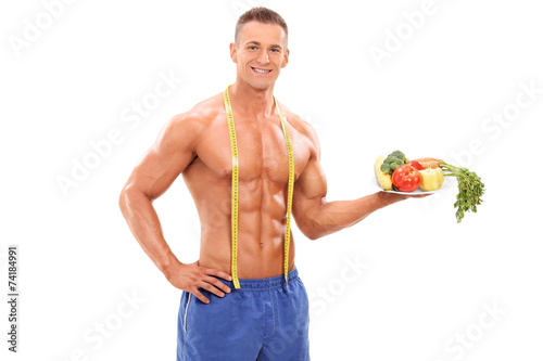 Shirtless athlete holding a plate with vegetables © Ljupco Smokovski