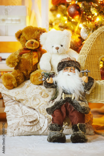 Santa and teddy bears under the decorated Christmas tree photo